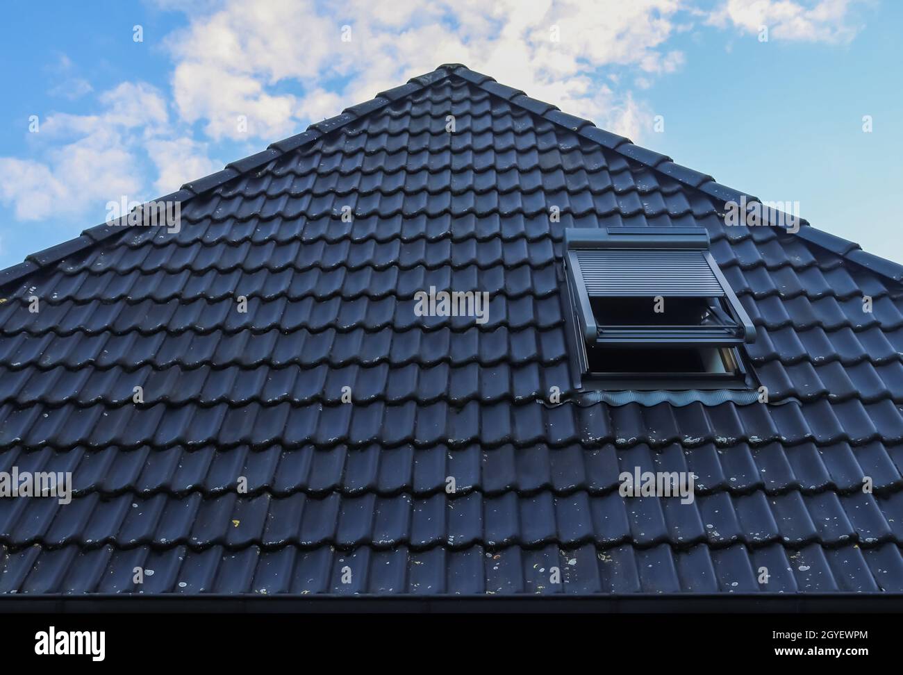 Open roof window in velux style with black roof tiles Stock Photo Alamy