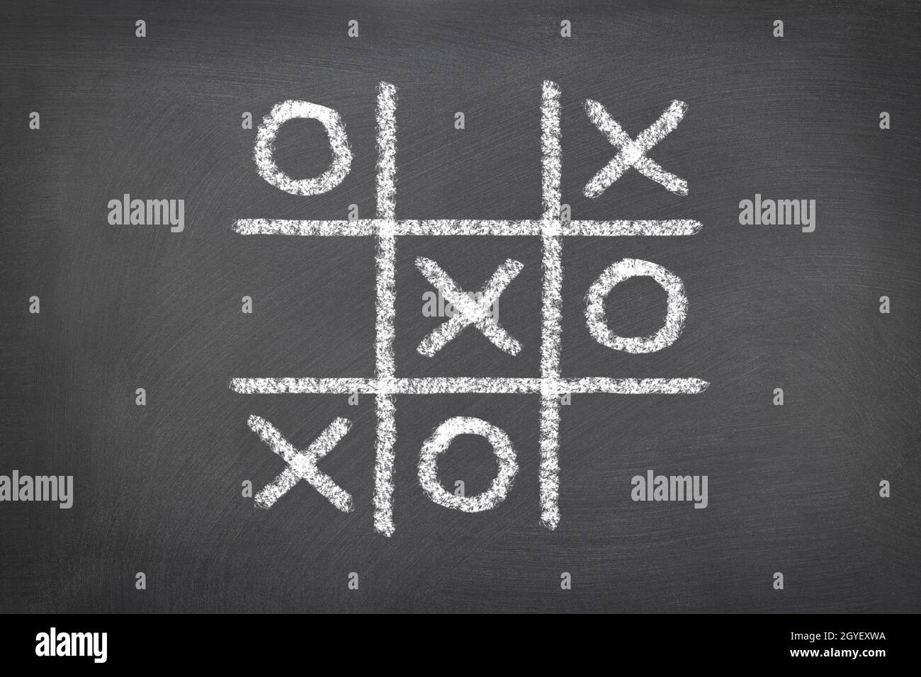 A game of tic tac toe played on a chalk board shows the need to be a critical thinker in the world of gaming. Stock Photo