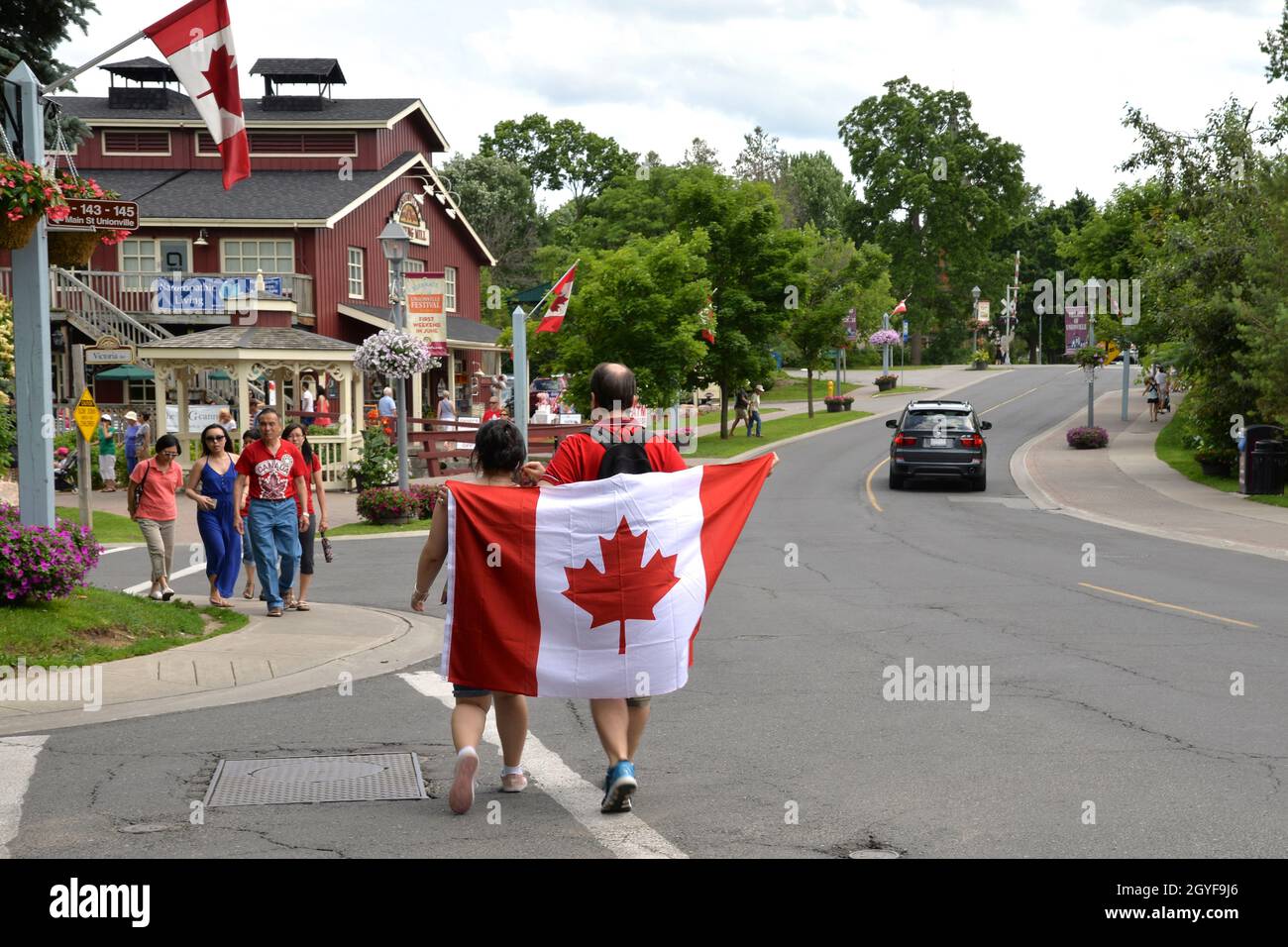 Couple holding flag at in the Canada Day parade Stock Photo