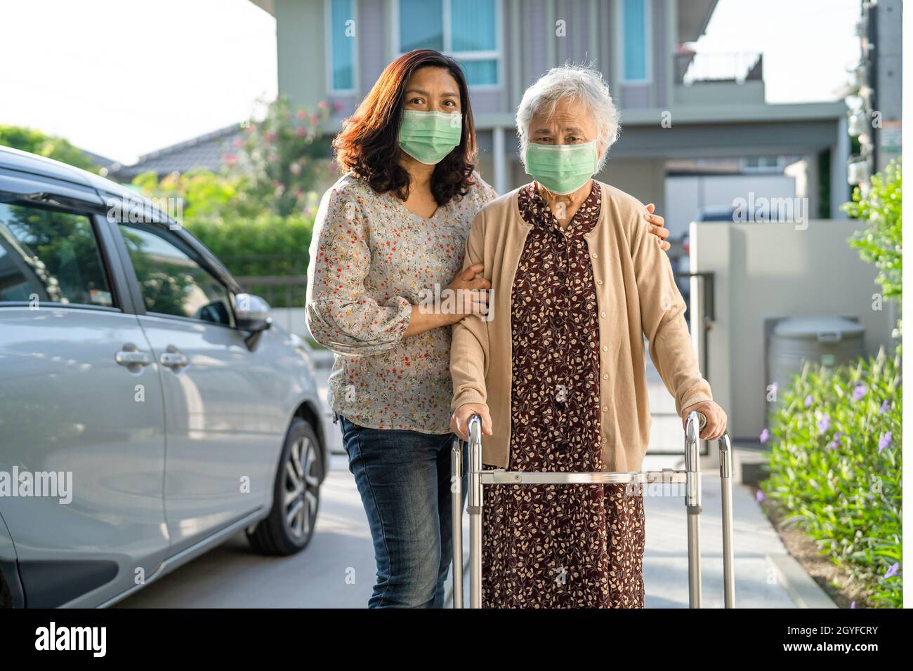 Asian senior or elderly old lady woman walk with walker and wearing a ...