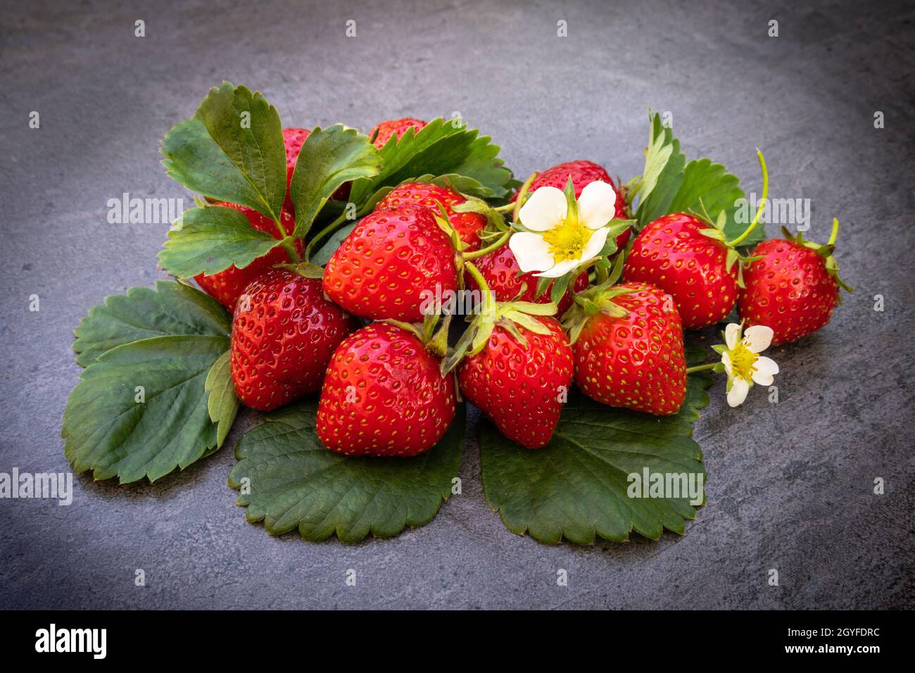 Red ripe strawberries with leaves over dark background Stock Photo - Alamy