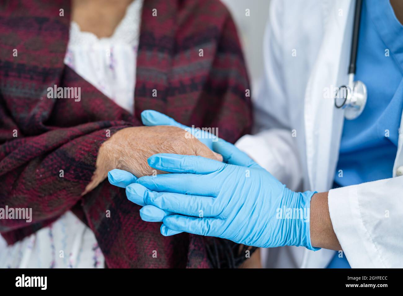 Doctor holding touching hands Asian senior or elderly old lady woman patient with love, care, helping, encourage and empathy at nursing hospital ward, Stock Photo