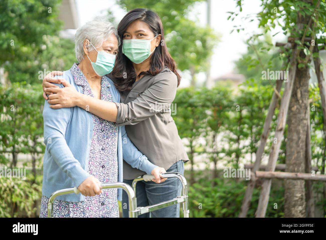 Asian senior or elderly old lady woman walk with walker and wearing a ...