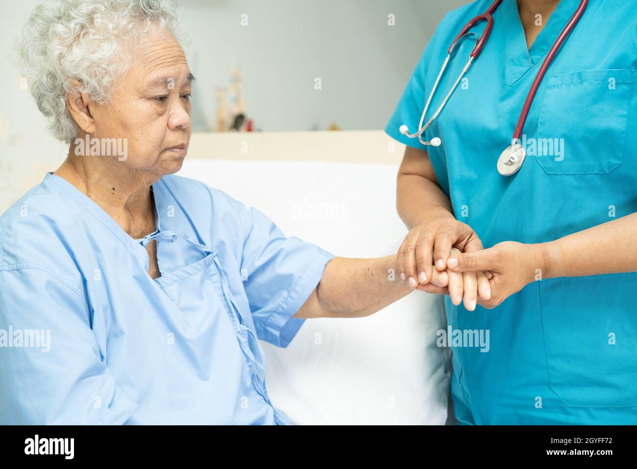 Touching Asian senior or elderly old lady woman patient with love, care, helping, encourage and empathy at nursing hospital ward : healthy strong medi Stock Photo