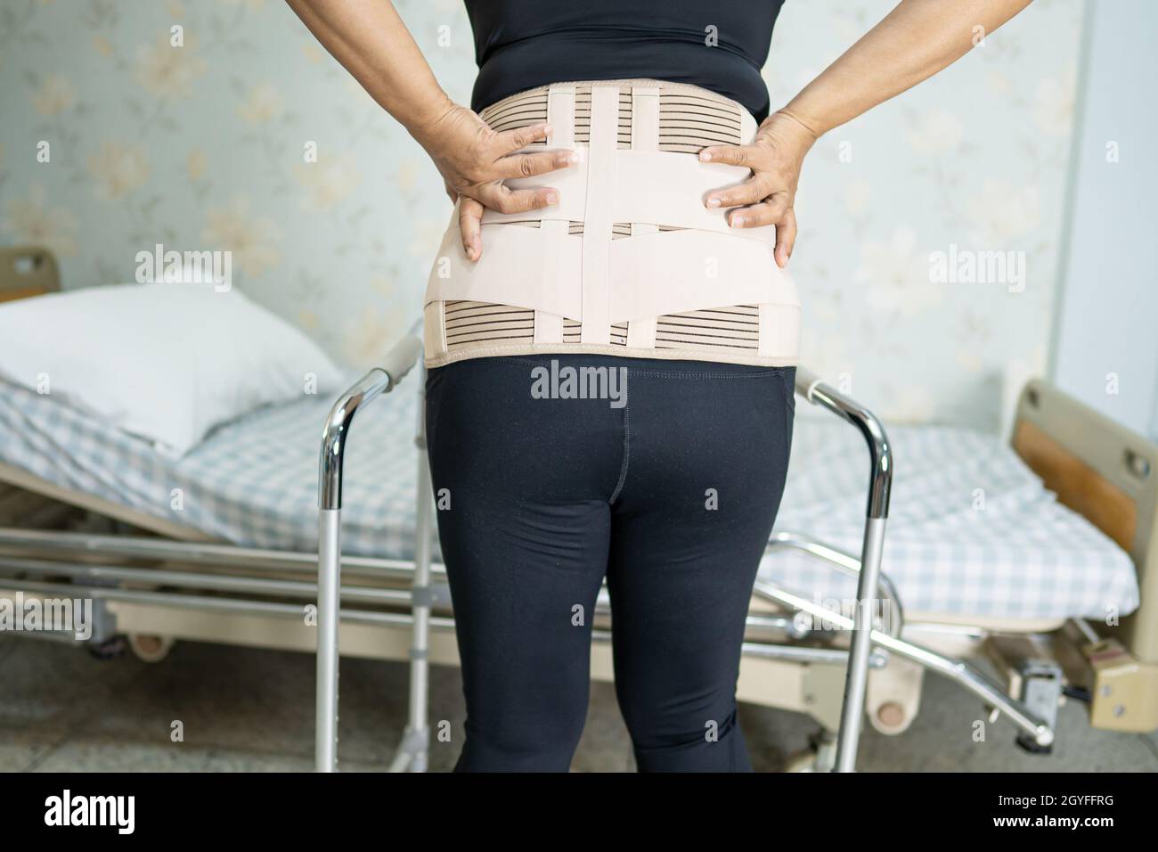 Asian lady patient wearing back pain support belt for orthopedic lumbar