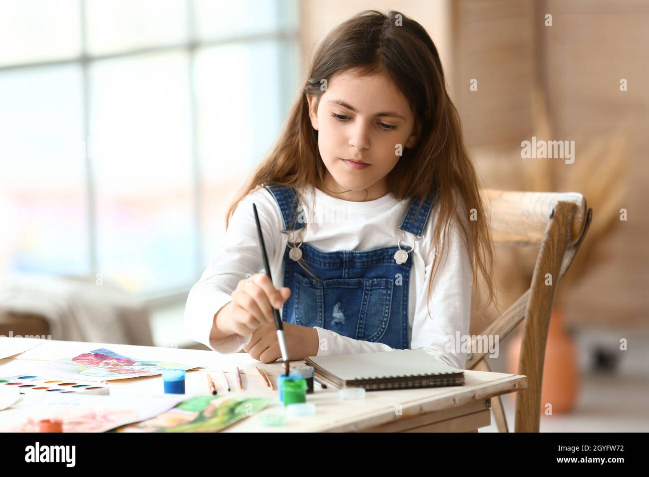 Cute little girl painting at home Stock Photo - Alamy
