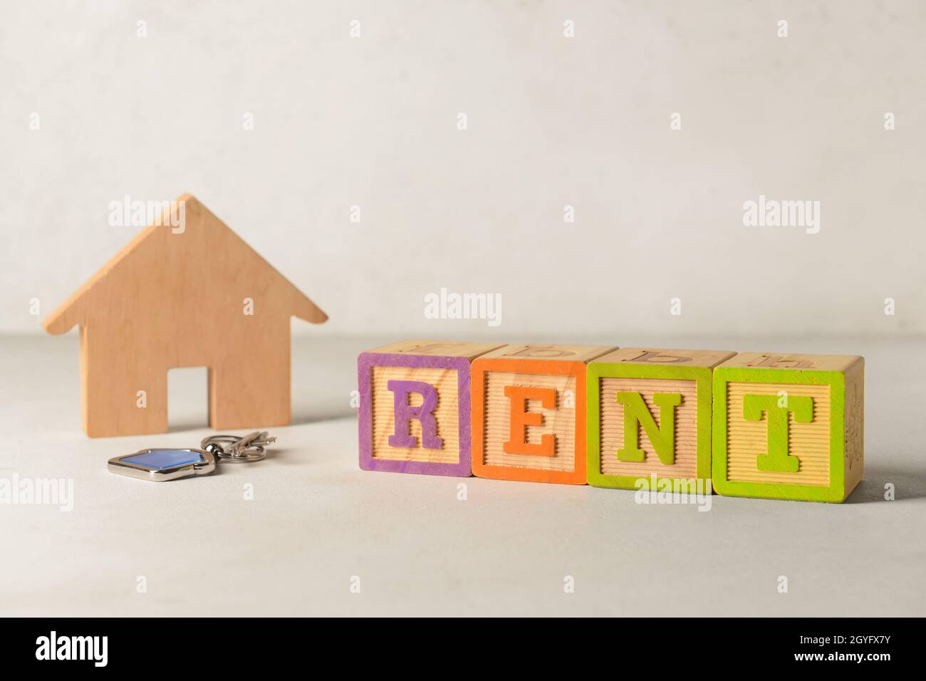 Wooden house with word RENT and key on white background Stock Photo - Alamy