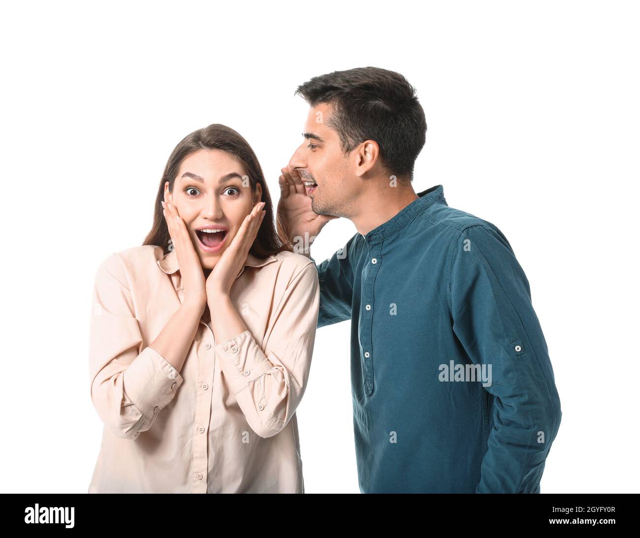 Young man sharing gossip with his girlfriend on white background Stock Photo