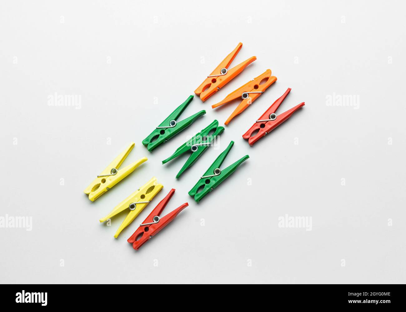 Different plastic clothespins on grey background Stock Photo