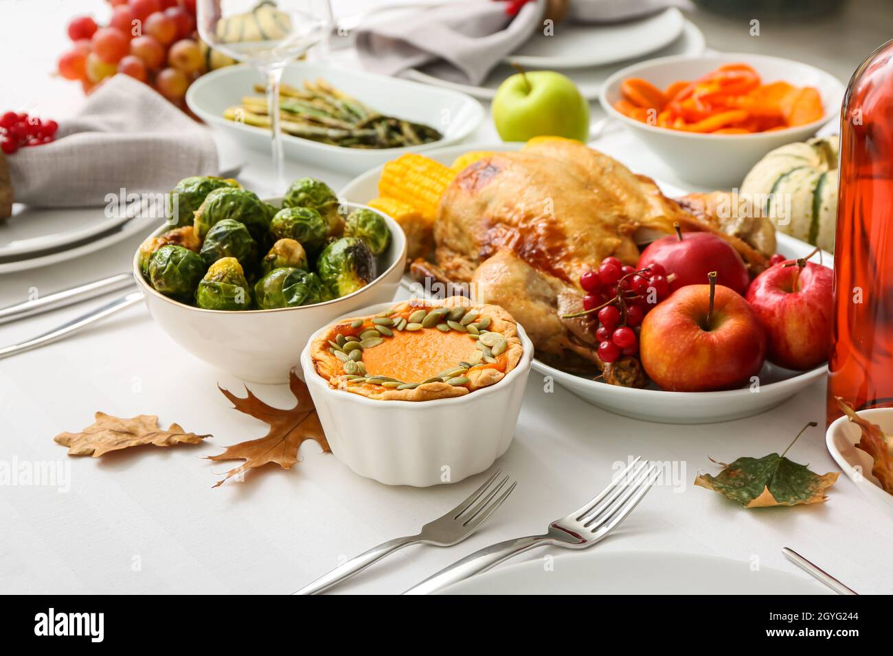 Bowl with pumpkin pie and dish with roasted turkey on table served for ...