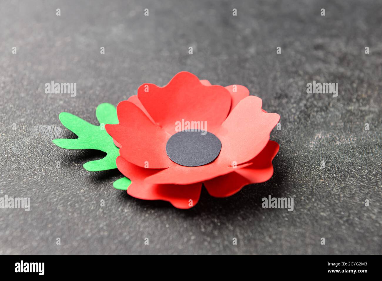 Paper poppy flower on dark background. Remembrance Day Stock Photo