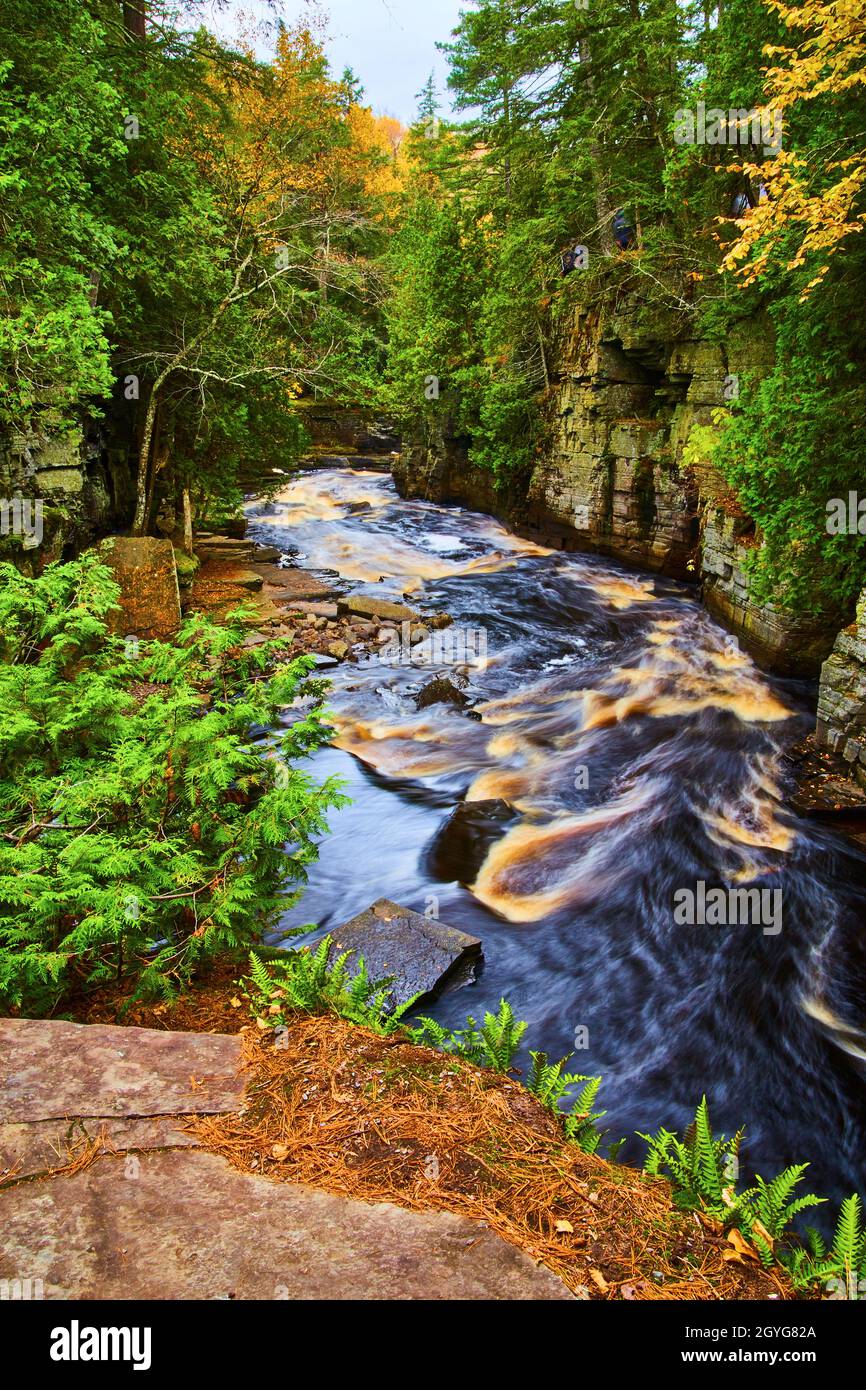 Flowing river with a few rapids as it passes through a gorge with rock cliff walls on either side Stock Photo