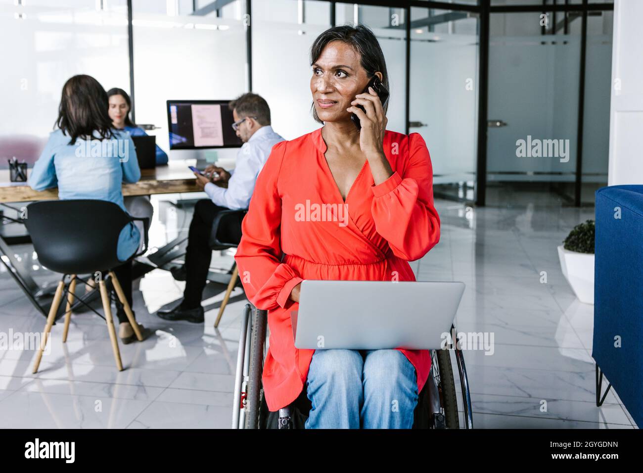 Hispanic transgender businesswoman in wheelchair busy calling on cell