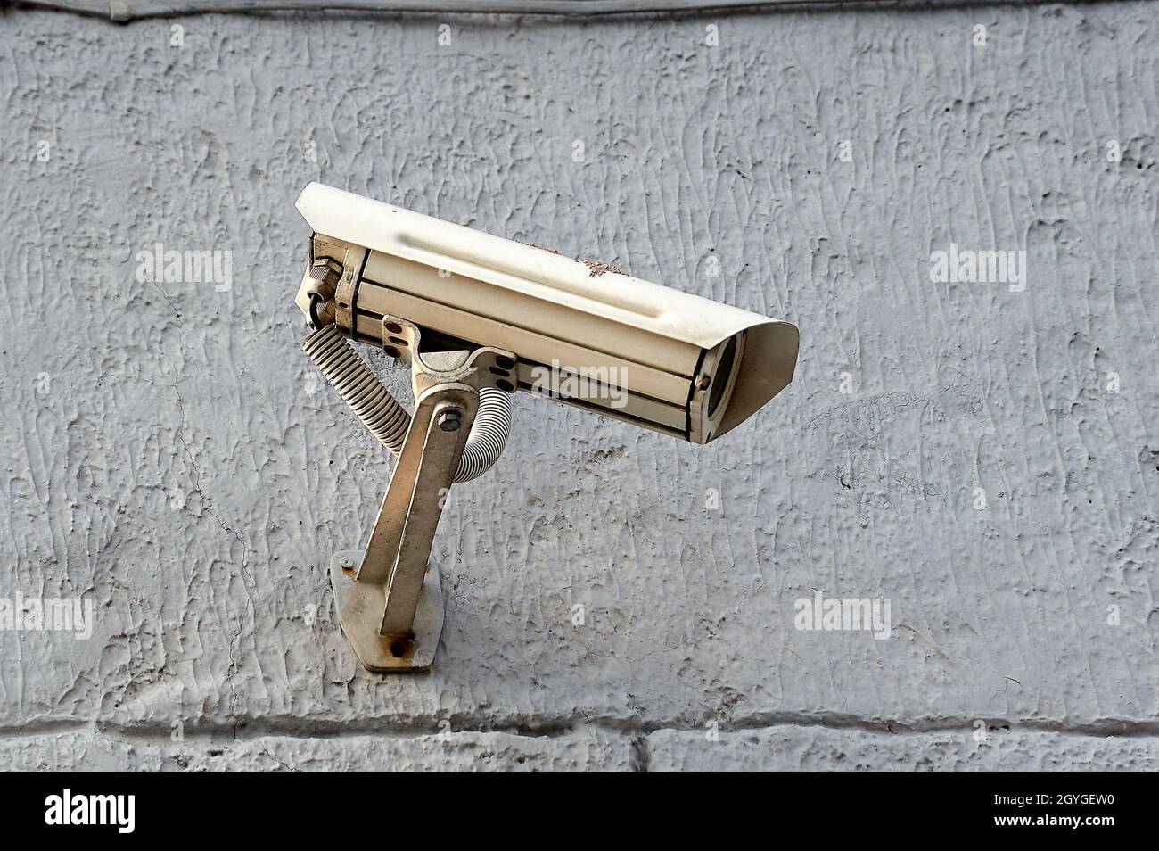 A security camera is hanging on a concrete post Stock Photo - Alamy