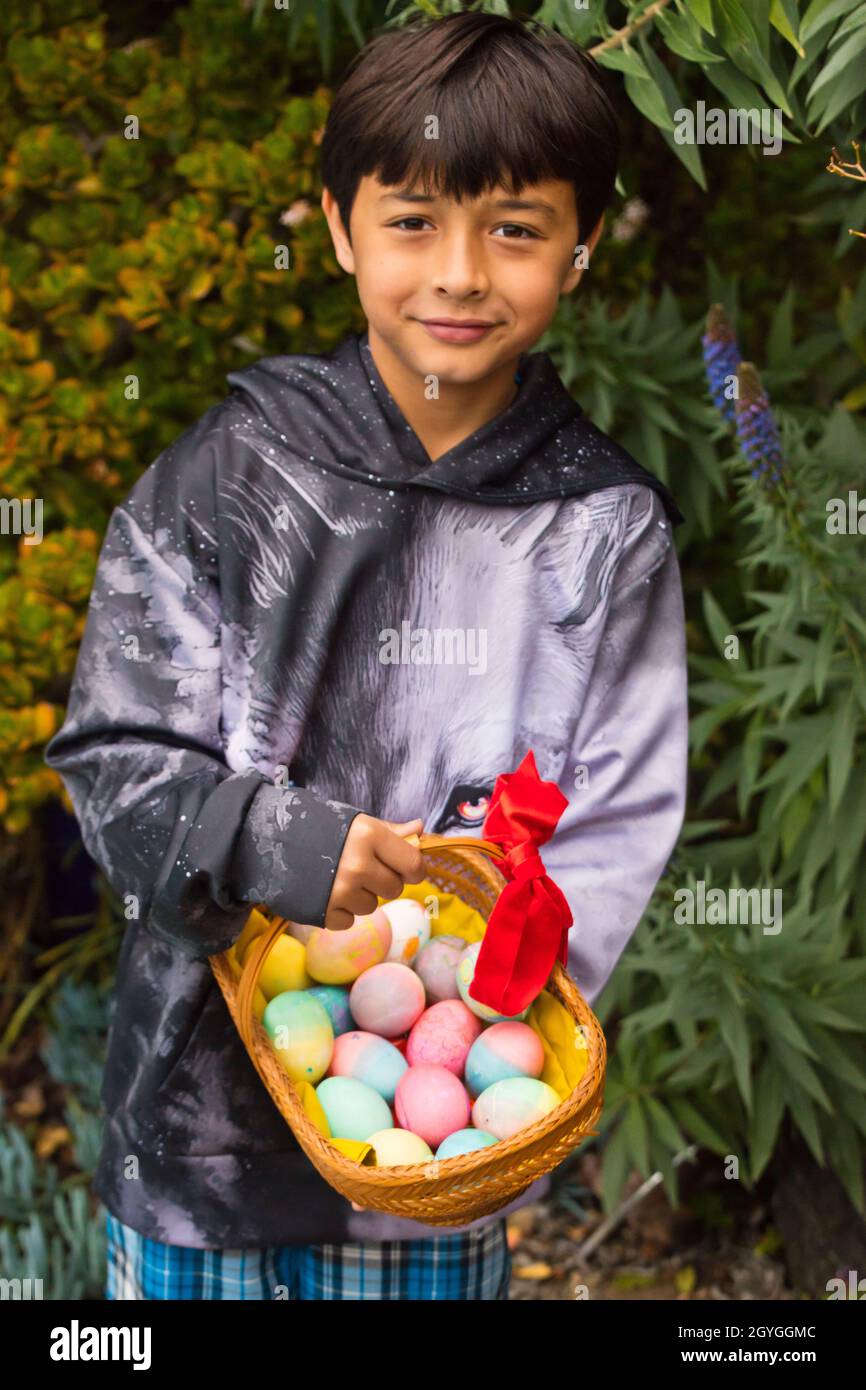 A nine year old  boy with a basket of Easter eggs. Stock Photo
