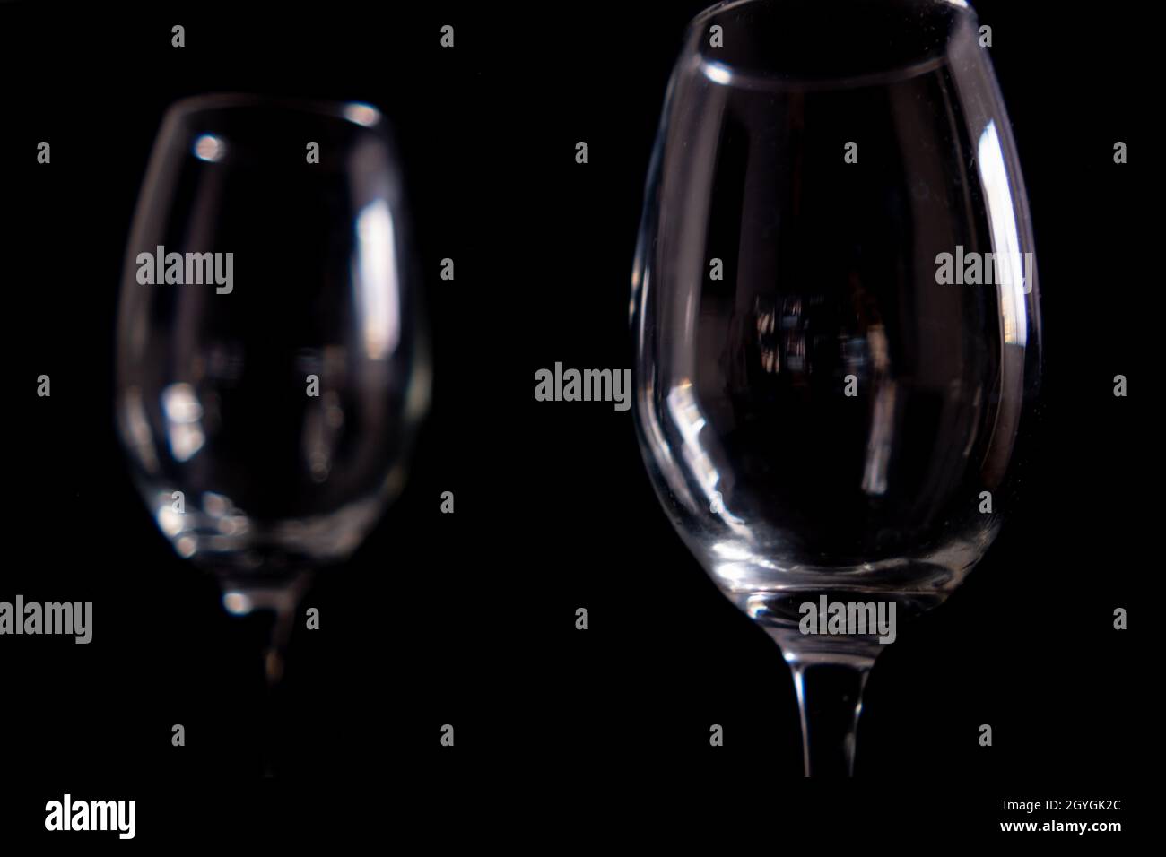 Light reflecting on empty glass goblets with black background Stock Photo