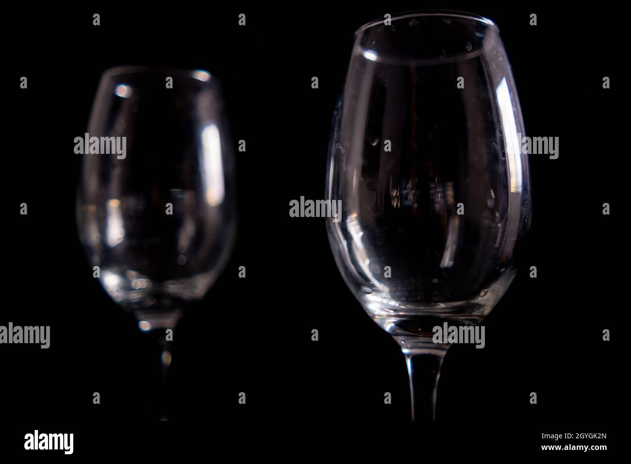 Light reflecting on empty glass goblets with black background Stock Photo