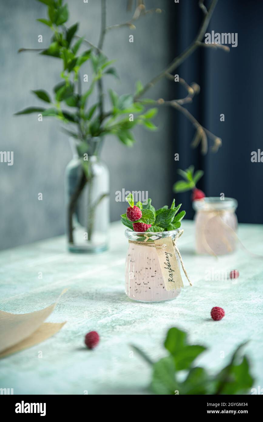 Still life with homemade detox drink made of raspberry, basil seeds, mint leaves and decorated with hand written label. Refreshing drink in natural li Stock Photo
