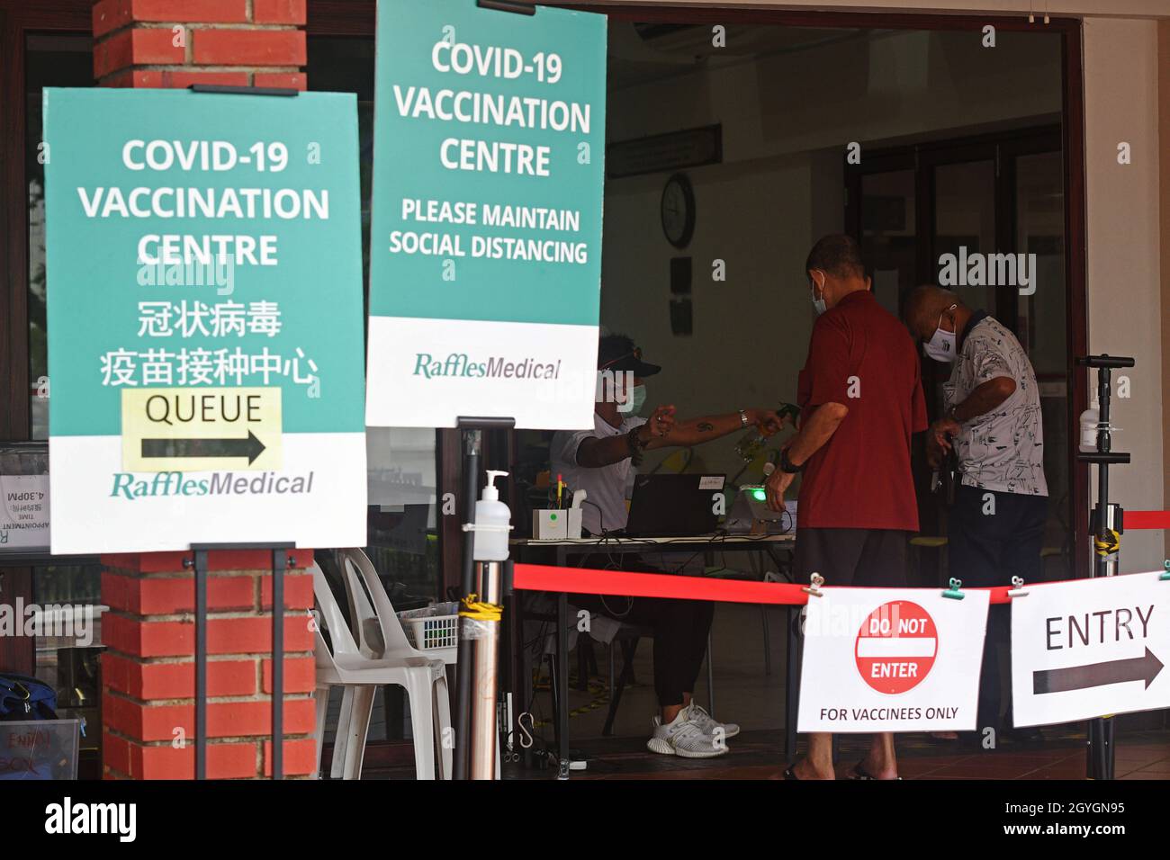 Singapore. 7th Oct, 2021. People register for COVID-19 vaccination at a vaccination center in Singapore on Oct. 7, 2021. Singapore reported 3,483 new cases of COVID-19 on Thursday, bringing the total tally in the country to 116,864. Credit: Then Chih Wey/Xinhua/Alamy Live News Stock Photo