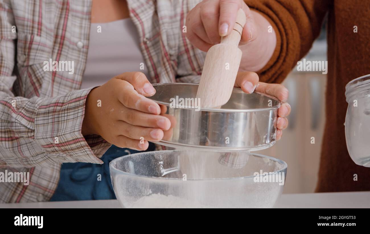 Closeup of grandchild strain flour ingredient in kitchen bowl preparing homemade cookie dough