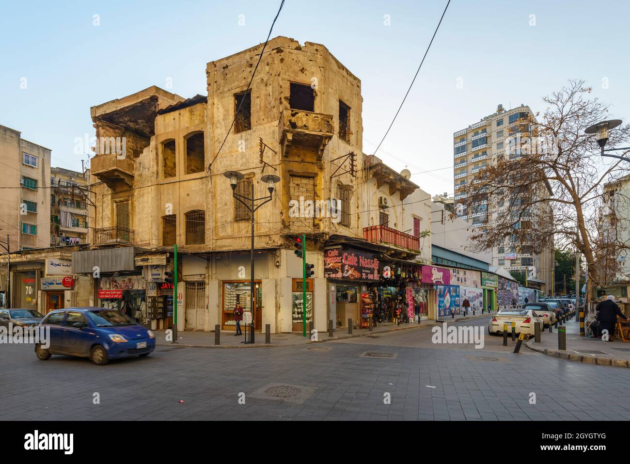 LEBANON, BEIRUT, MAZRAA, BUILDING WITH BULLET HOLES AND TRADE ON THE GROUND FLOOR AT THE CORNER OF OUZAI AND MAZRAA STREETS Stock Photo