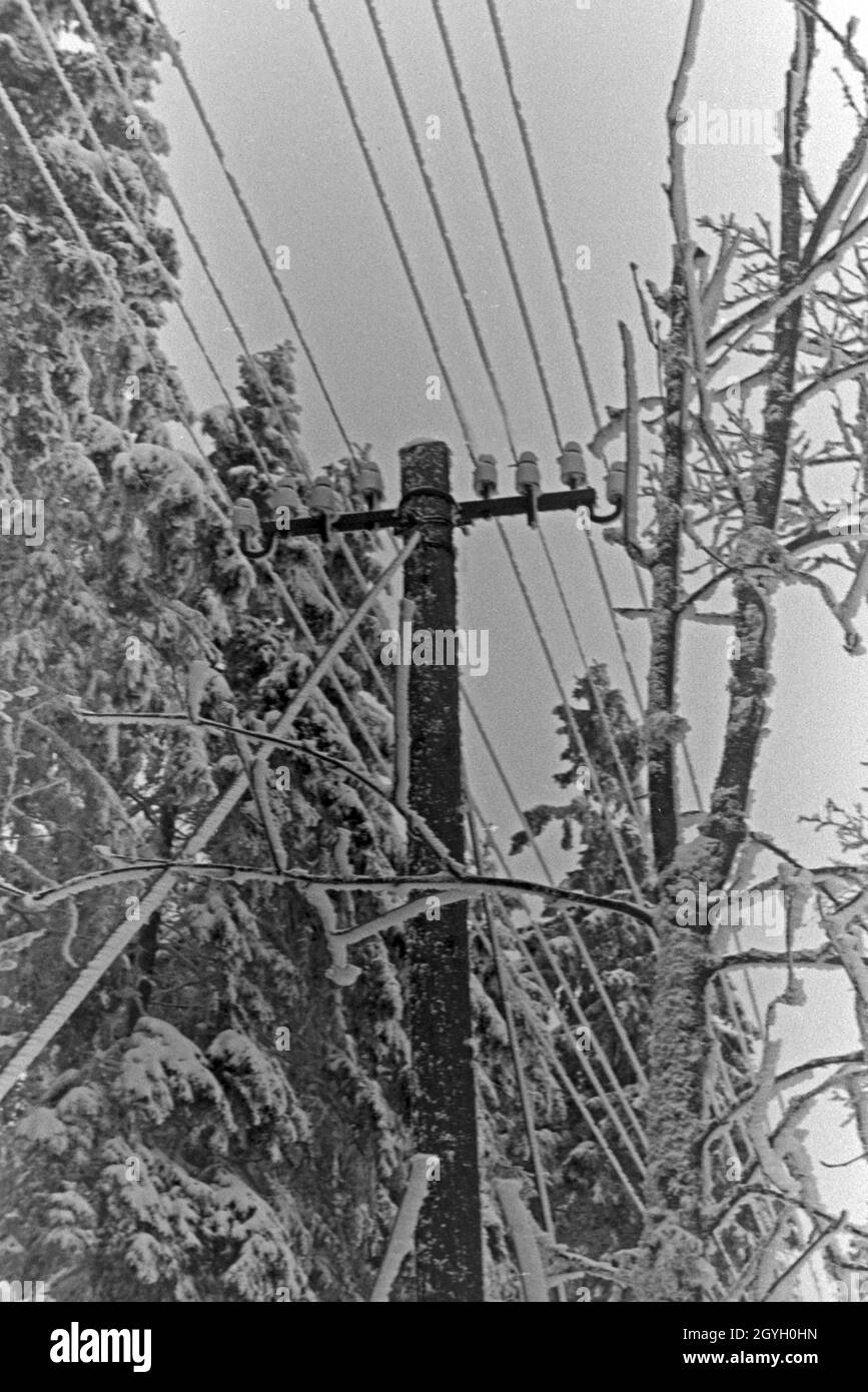 Eingeschneiter Telegrafenmast in einer Winterlandscchaft, Deutschland 1930er Jahre. Snowed in telegraph pole in a winter landscape, Germany 1930s. Stock Photo