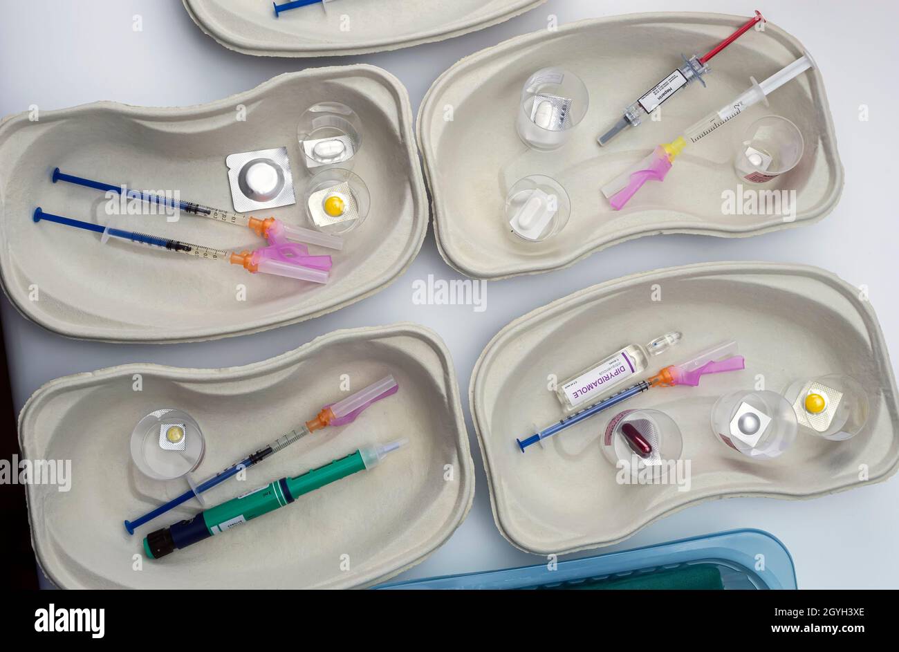 Diverse medication in glasses monodose along with insulin injectors in hospital, conceptual image Stock Photo