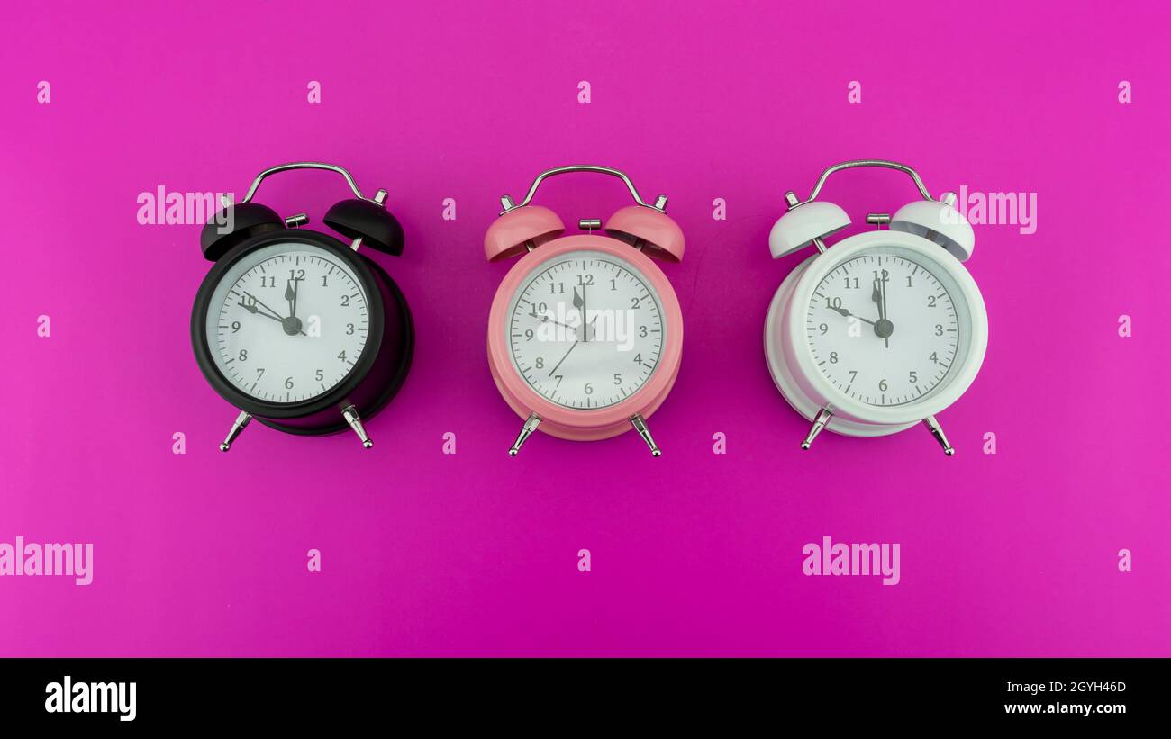 Twelve o Clock on New Years Eve of Face of Beautiful three alarm clock, indicating midnight Adorable New Year celebration Concept Happy new year 2022 Stock Photo
