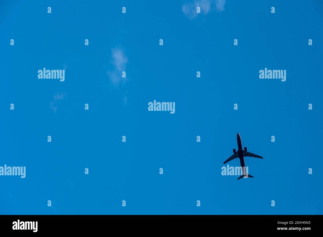 Airplane flying in the blue sky Stock Photo - Alamy