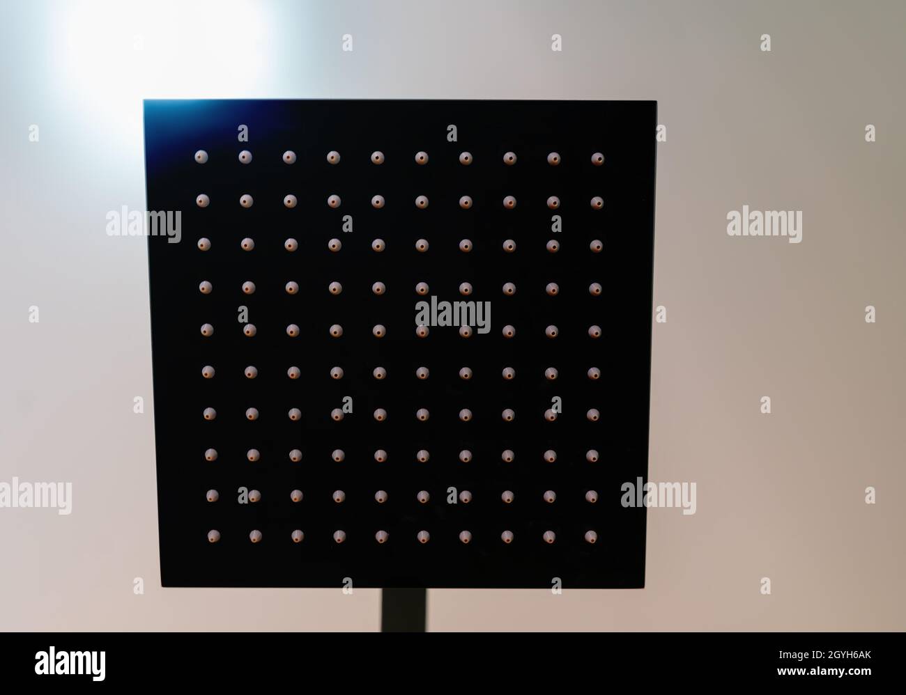 Large modern square shower head with multiple rows of nozzles viewed