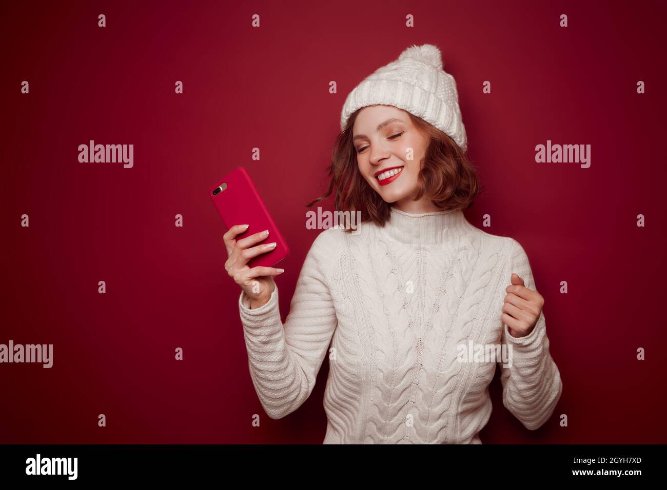 Happy smiling woman in sweater hold phone Stock Photo
