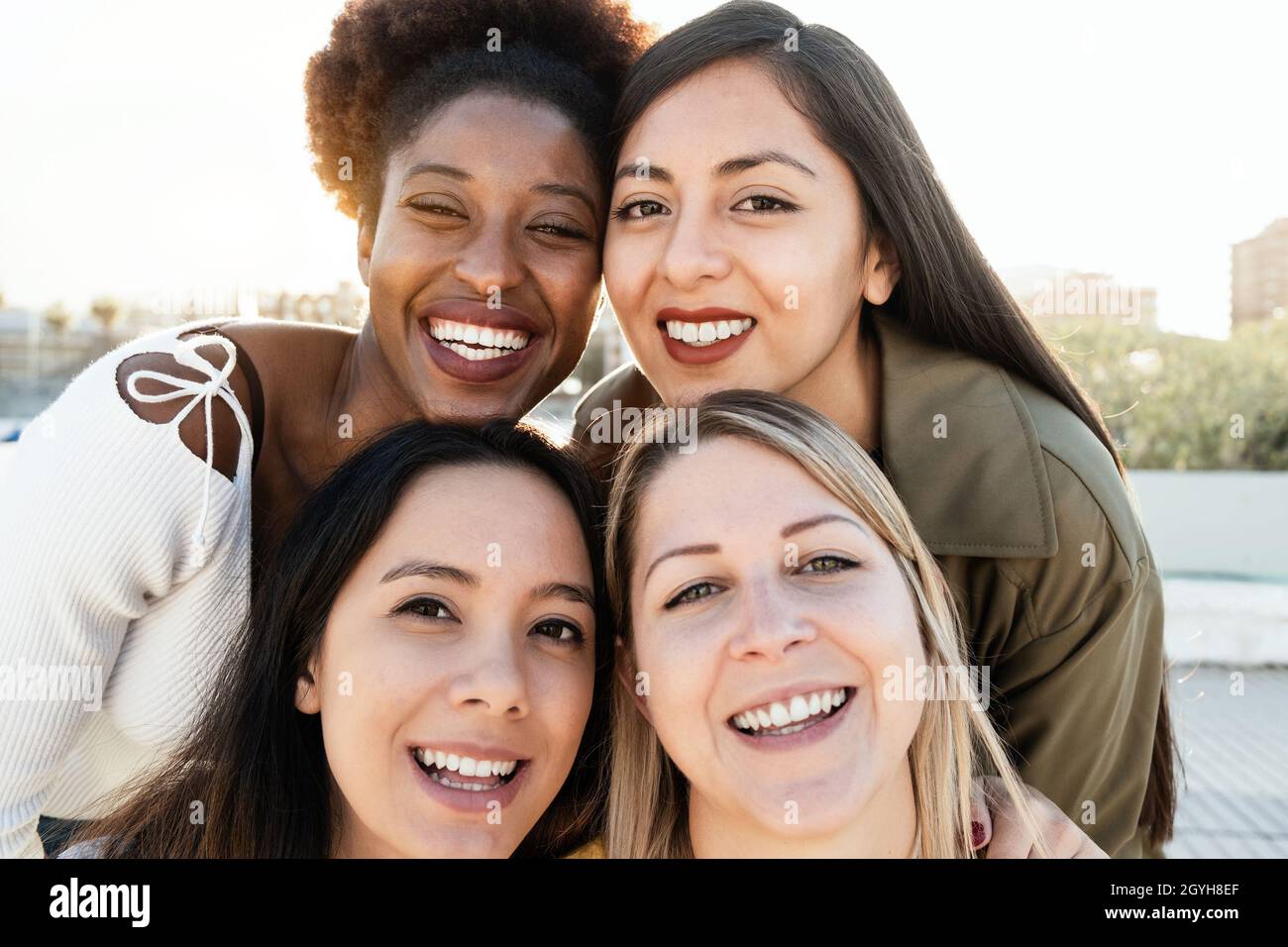 Multiracial friends having fun together doing selfie outdoor - Focus on ...