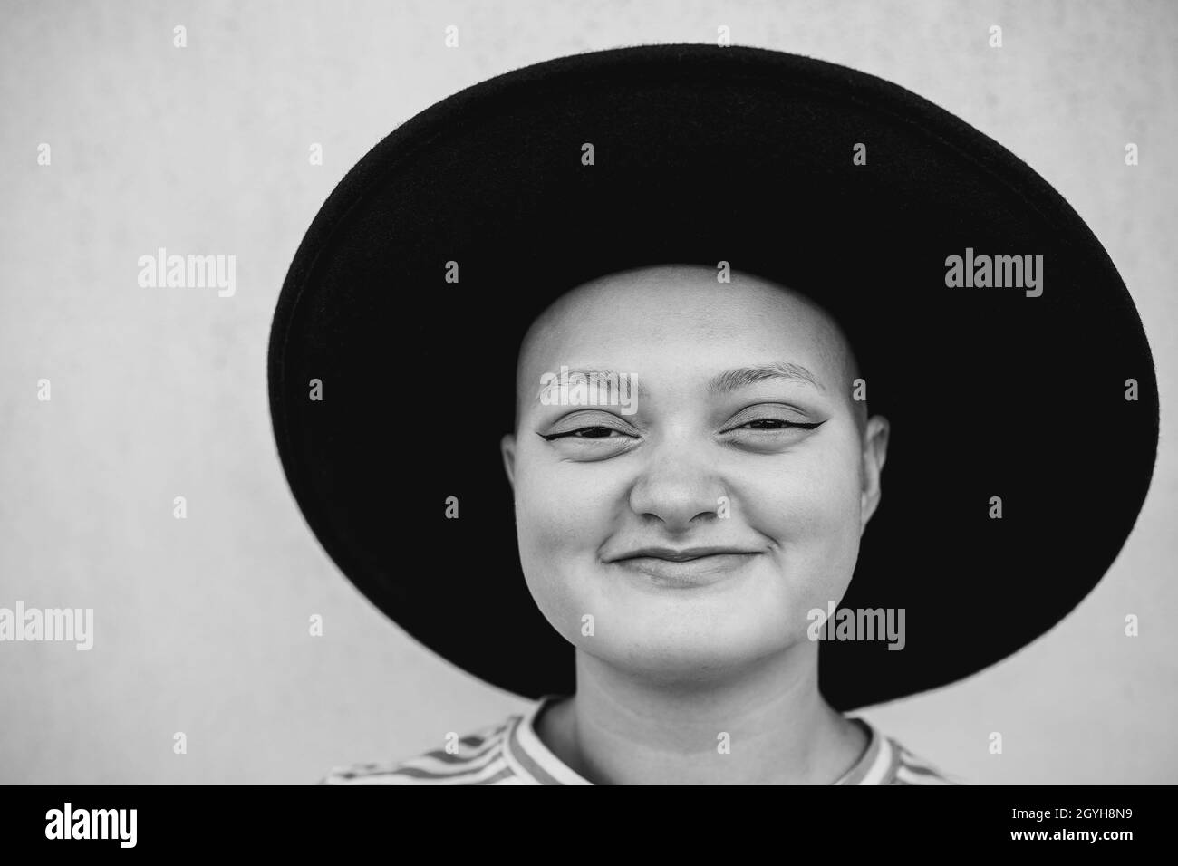 Happy bald girl smiling on camera outdoor - Focus on face Stock Photo