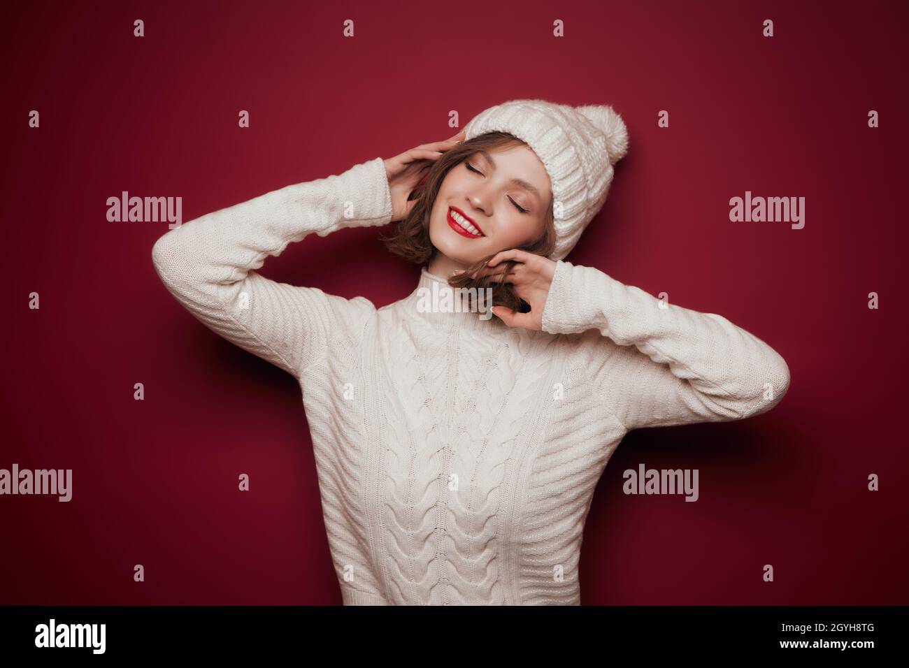 Dreamy smiling woman in knitted hat and sweater Stock Photo