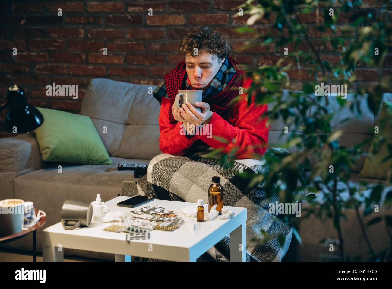 Portrait of young man feeling bad, having cold and flu. Self-isolation ...
