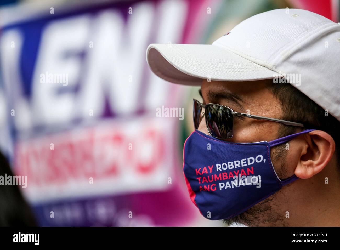 Quezon City, Metro Manila, Philippines. 8th October 2021. A supporter wears a protective mask with a sign for Vice President Leni Robredo before announcing her presidential bid for the 2022 national elections. After a long-anticipated decision, Leni Robredo announced her presidential bid leading her to another competition with the son of the late dictator Ferdinand Marcos who is also seeking for presidency. Credit: Majority World CIC/Alamy Live News Stock Photo