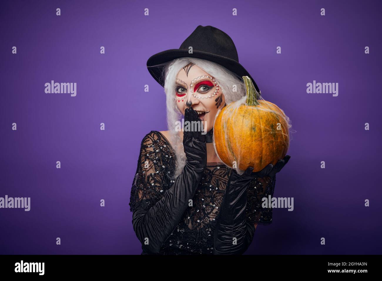 Cheerful young woman with Halloween make-up and pumpkin Stock Photo
