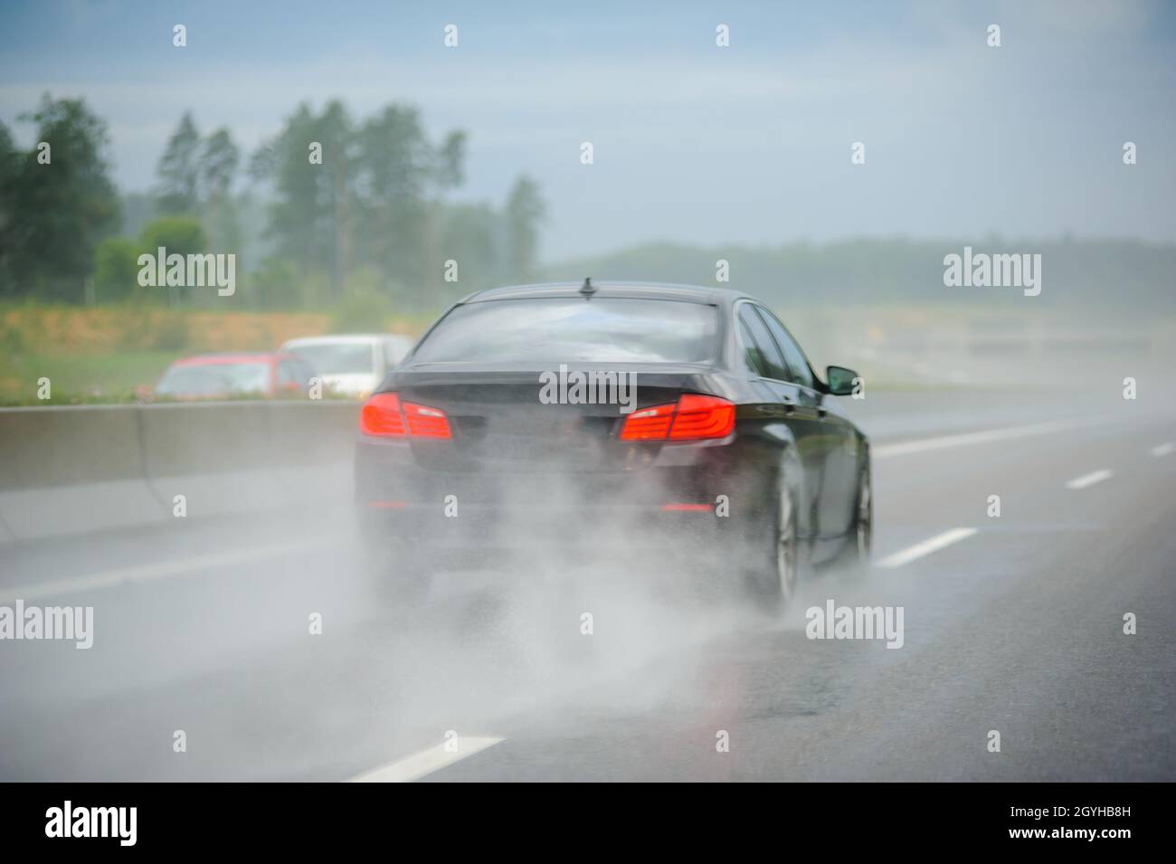 Rear view of car driving fast on German highway autobahn during rainy ...