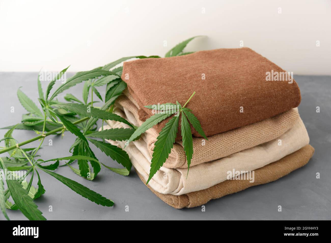 Stack of hemp clothes with cannabis leaves Stock Photo