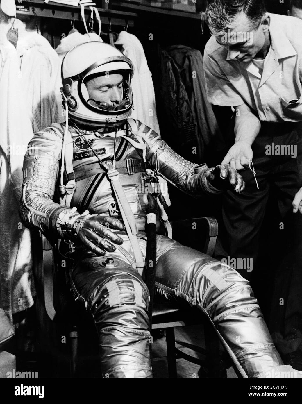 (1961) --- Mercury astronaut M. Scott Carpenter, prime pilot for the Mercury-Atlas 7 (MA-7) spaceflight, and Crew Equipment Specialist Joe Schmidt are pictured during a suiting exercise. Schmidt is seen checking the gloves on Carpenter's pressure suit. Stock Photo