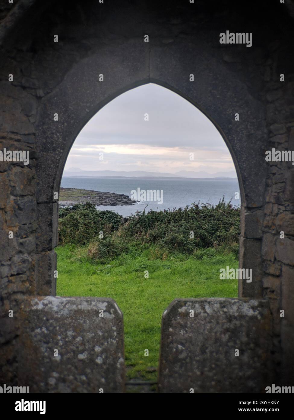 Stone wall and arch of an old castle or fortification facing the sea ...