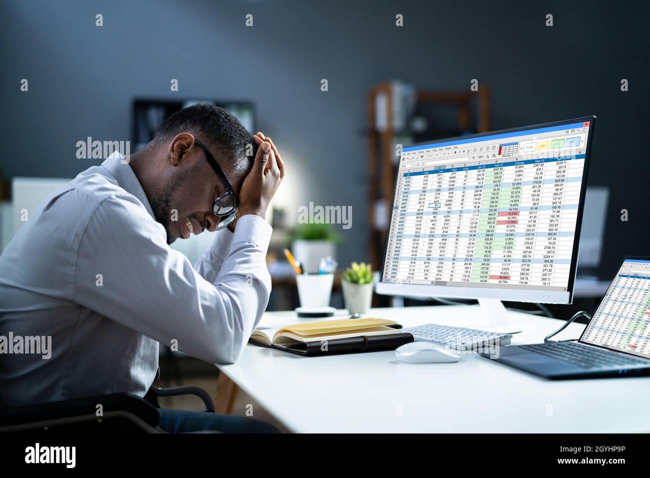 Stressed Depressed African Man At Desk. Tired Bored Businessman Stock Photo