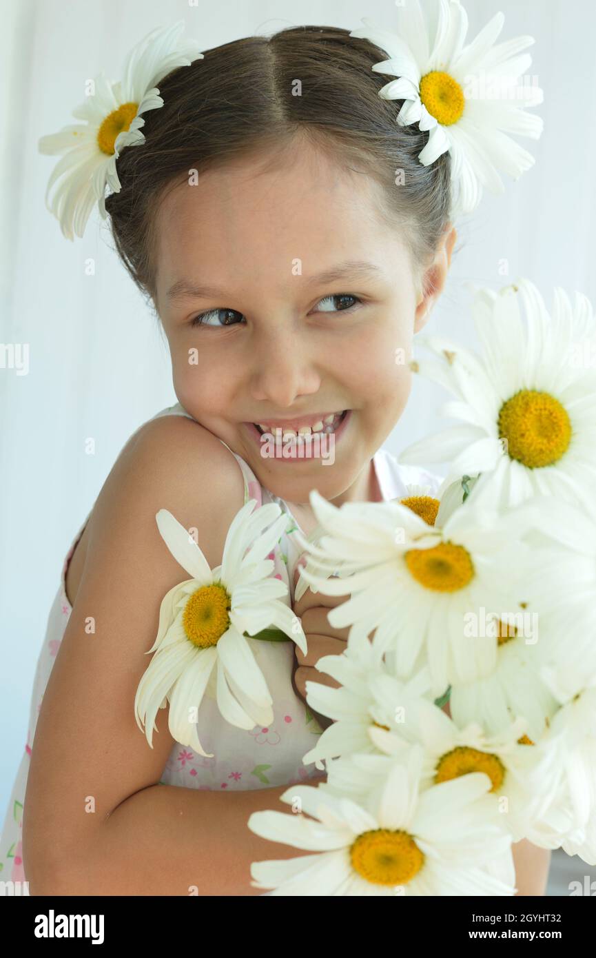 Cute little girl at home with chamomile Stock Photo - Alamy