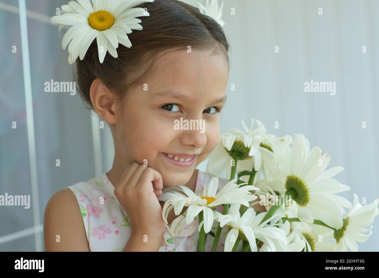 Cute little girl at home with chamomile Stock Photo - Alamy