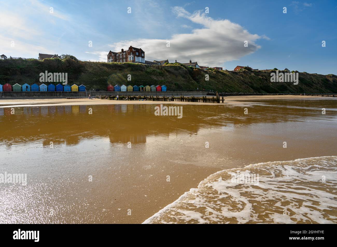 Mundesley beach with beach huts and clifftop with houses seen from the