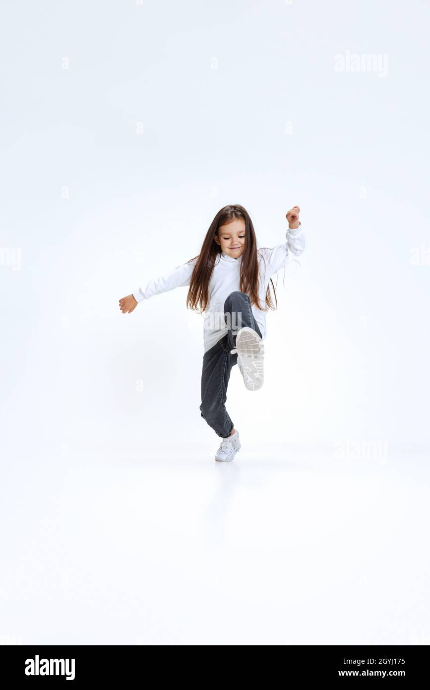 Fulllength portrait of little cute girl, kid wearing hoodie with jeans