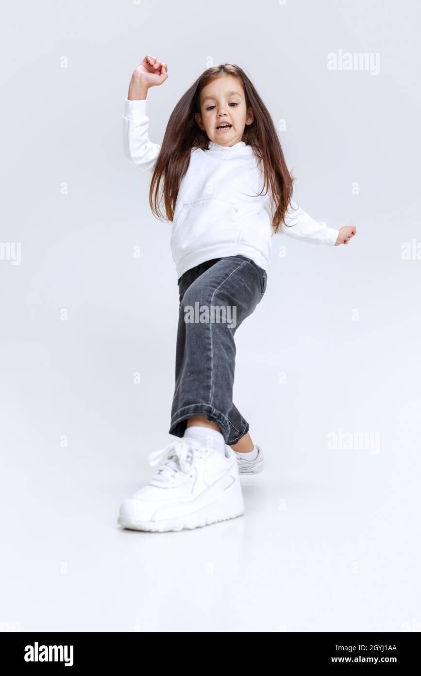 Fulllength portrait of little cute girl, kid wearing hoodie with jeans