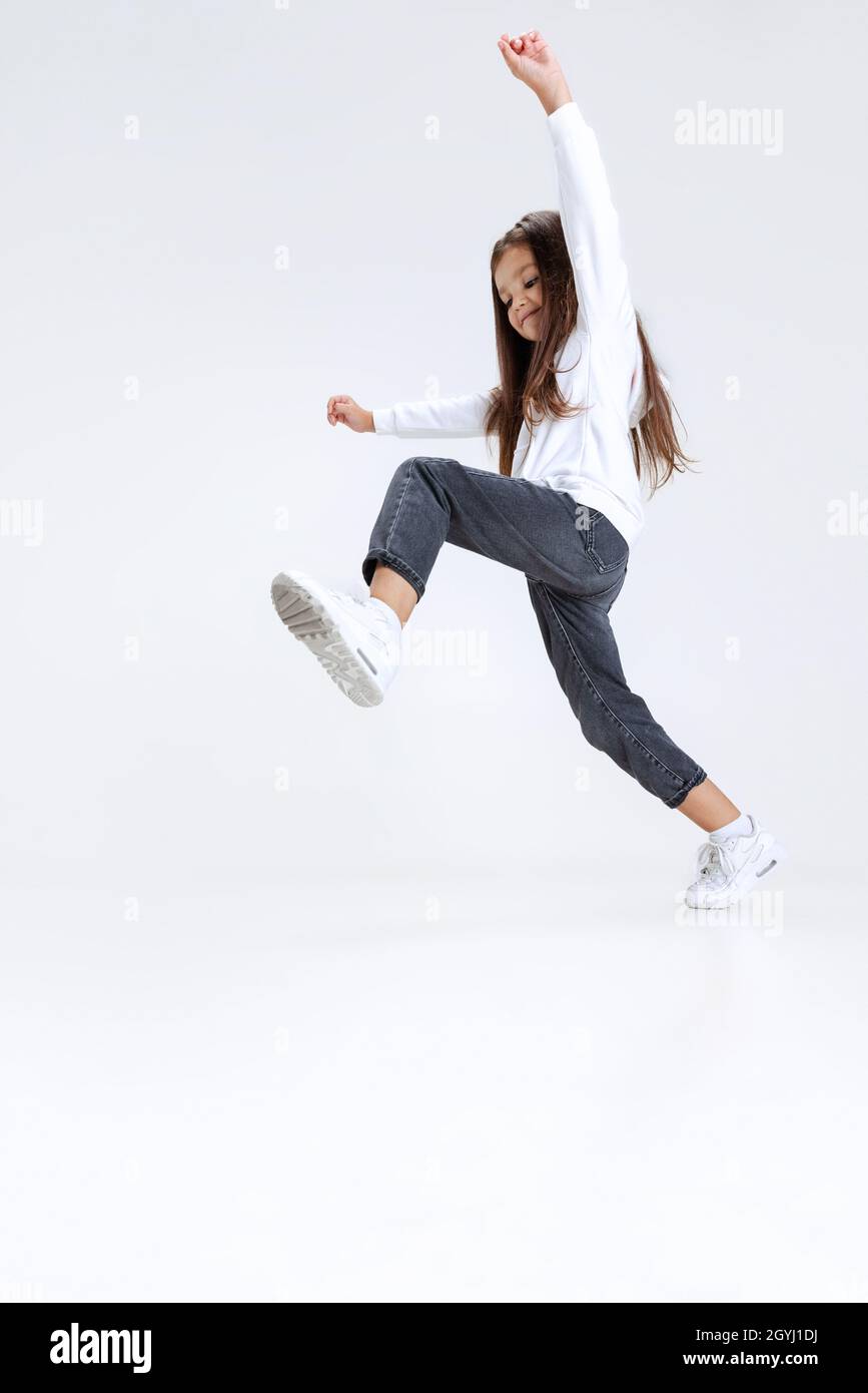 Fulllength portrait of little cute girl, kid wearing hoodie with jeans