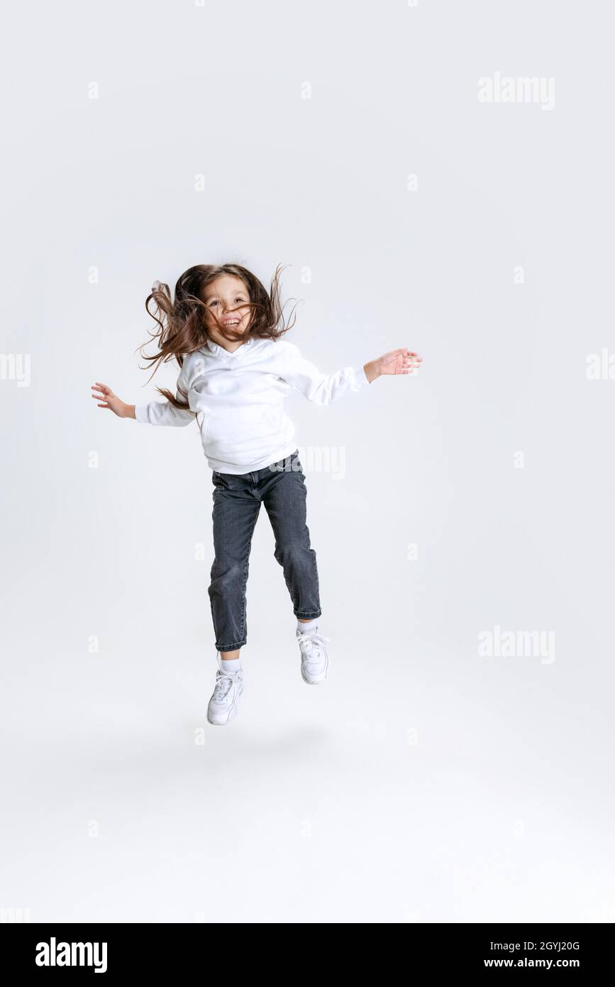 Fulllength portrait of little cute girl, kid wearing hoodie with jeans
