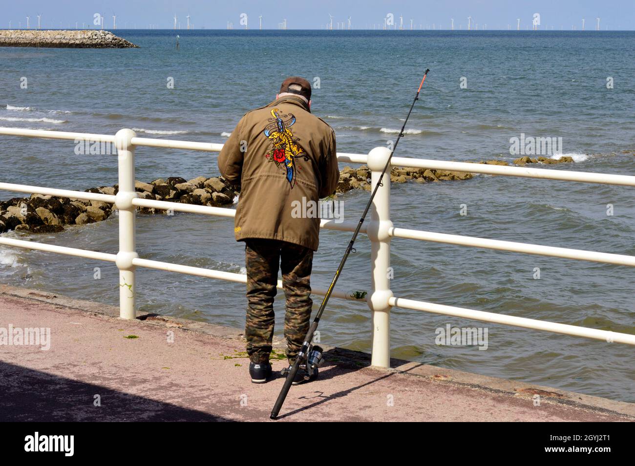 COLWYN BAY. CONWY COUNTY. WALES. 06-19-21. Rhos on Sea, a sea angler fishing from the promenade. Stock Photo